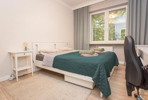 Schlafzimmer mit einem Bett, einem Schreibtisch und einem Fenster in der Unterkunft Duży apartament w centrum przy rynku in Białystok