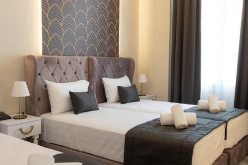 a hotel room with two beds with white pillows at Modern Revival Luxury Hotel in Thessaloniki