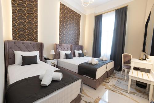a bedroom with two beds and a living room at Modern Revival Luxury Hotel in Thessaloniki