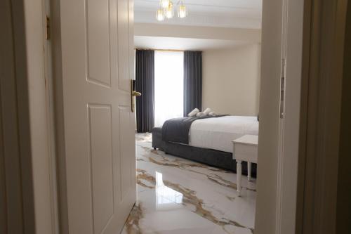 a bedroom with a bed and a table and a window at Modern Revival Luxury Hotel in Thessaloniki