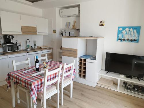 a kitchen with a table and chairs and a television at CHERISH in Novalja