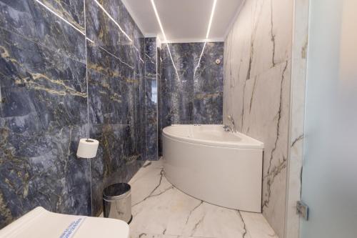 a bathroom with a toilet and a sink and a tub at Modern Revival Luxury Hotel in Thessaloniki