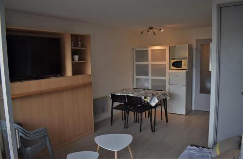 une cuisine et une salle à manger avec une table et des chaises dans l'établissement studio cabine 100m plage, au Grau-du-Roi