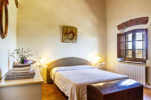 sypialnia z łóżkiem i oknem w obiekcie Appartamento gli Archi w mieście Civitella Marittima