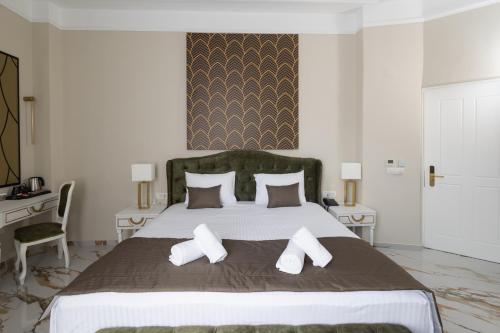 a bedroom with a large bed with three pillows at Modern Revival Luxury Hotel in Thessaloniki