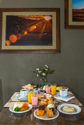 a table with plates of food and glasses of orange juice at Pousada UpSerra in Urubici