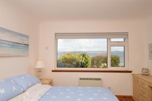 a bedroom with a bed and a large window at Bay View in Lochgilphead