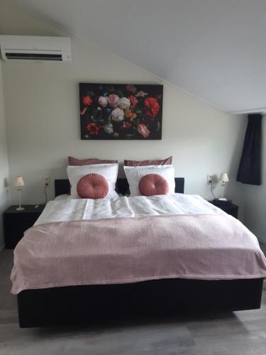 een slaapkamer met een groot bed met 2 kussens bij Gastenverblijf De Handwijzer in Hengelo