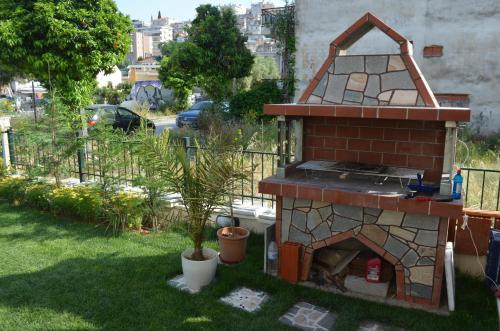 un horno de ladrillo en un patio con una planta en GreenCity Kavala, en Kavala