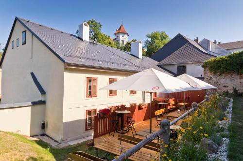 una casa con terraza con mesas y sombrillas en Měšťanský dům - kulturní památka Mlýnská 119 en Jindrichuv Hradec