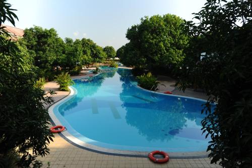 an overhead view of a large blue swimming pool at Madhubhan Resort & Spa in Anand