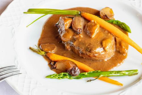 a plate of food with meat and vegetables on it at Hotel Restaurante La Glorieta in La Seu d'Urgell