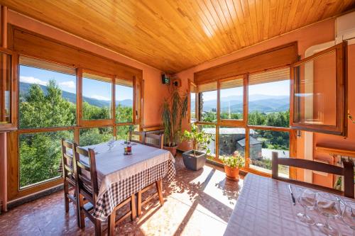 a dining room with a table and some windows at Hotel Restaurante La Glorieta in La Seu d'Urgell