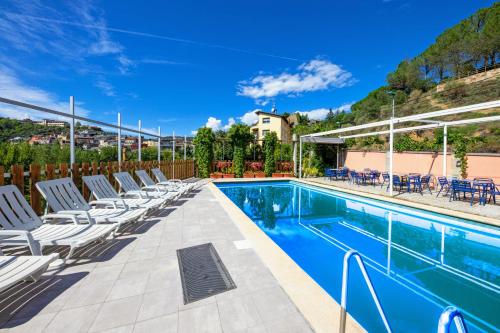 una piscina con tumbonas junto a una piscina en Hotel Restaurante La Glorieta en La Seu d'Urgell