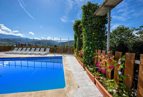 a swimming pool in a yard with chairs and flowers at Hotel Restaurante La Glorieta in La Seu d'Urgell