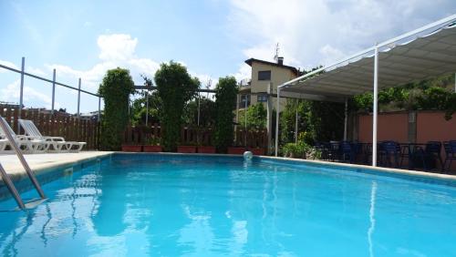a swimming pool with blue water in front of a fence at Hotel Restaurante La Glorieta in La Seu d'Urgell