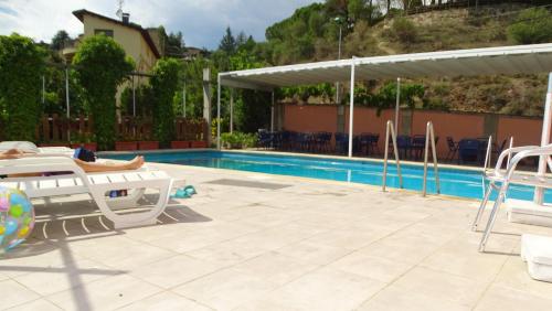 a pool with a table and chairs next to a building at Hotel Restaurante La Glorieta in La Seu d'Urgell