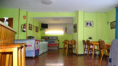a dining room with green walls and a table and chairs at Hotel Restaurante La Glorieta in La Seu d'Urgell