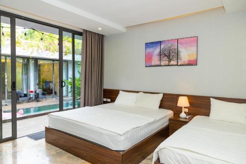 um quarto com 2 camas e uma janela em Villa DoQuyen F5b Flamingo Dai Lai resort em Ngọc Quang