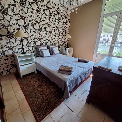 une chambre avec un lit avec une couette bleue dans l'établissement Le vent dans les voiles - Appartement classé 4 étoiles, à Mèze