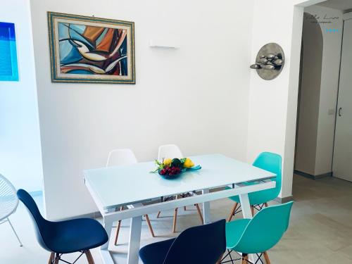 una sala da pranzo con tavolo e sedie bianchi di Villa Lina a Castiglioncello