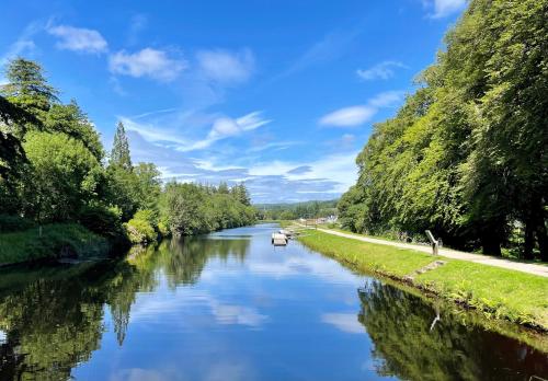 a river with a boat in the middle at Bay View in Lochgilphead