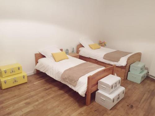 dwa łóżka w pokoju z pudełkami na podłodze w obiekcie Maison 3,5km de la plage et proche Mont St Michel w mieście Saint-Broladre
