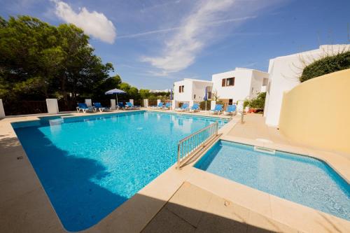 a large swimming pool with blue water at Apartamentos Sa Cornisa in Cala Morell