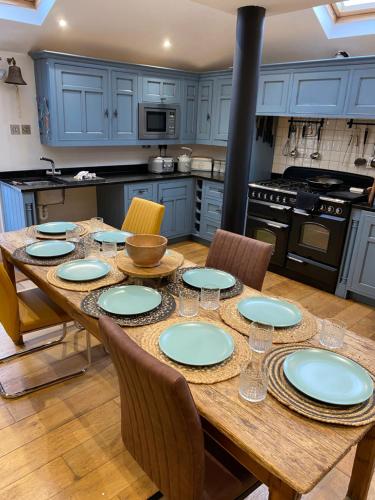 a kitchen with a wooden table with plates on it at The Patch in Hill Head