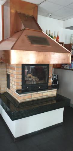 a brick fireplace in a kitchen with a hood at Penzion U Skály in Kytlice