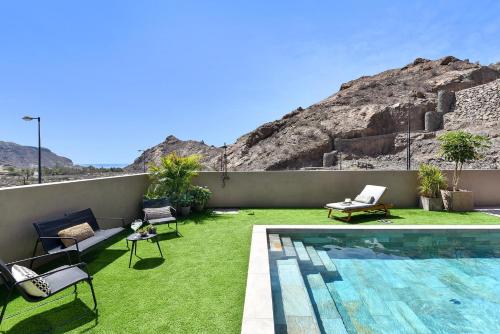 einen Hinterhof mit Pool und grünem Gras in der Unterkunft Almadies Tauro by VillaGranCanaria in Mogán