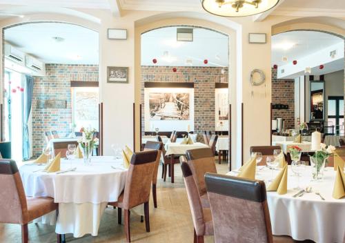 een eetkamer met witte tafels en stoelen bij Stara Szkoła Boutique Hotel in Wronki