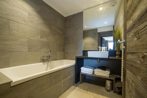 La salle de bains est pourvue d'une baignoire et d'un lavabo. dans l'établissement Bolquère I Chalet Boolly 5 étoiles luxe et bois I Vue montagne, à Bolquère-Pyrénées 2000