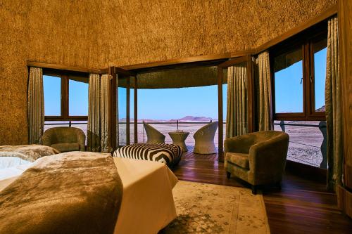 1 Schlafzimmer mit 2 Betten und Blick auf die Wüste in der Unterkunft Desert Hills Lodge in Sesriem