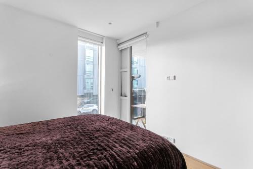 1 dormitorio con paredes blancas y 1 cama con manta en Cozy and Modern Apartment - Best Location in Reykjavík, en Reikiavik