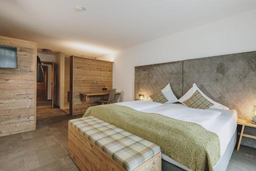 a bedroom with a large bed and a television at Der Gollinger in Saalbach Hinterglemm