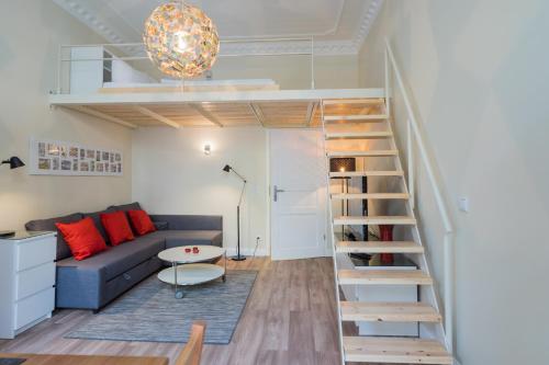 ein Wohnzimmer mit einem Sofa und einer Wendeltreppe in der Unterkunft Urban Comic in Berlin