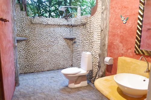a bathroom with a shower with a toilet and a sink at Bamboo Bungalows in Ko Phayam
