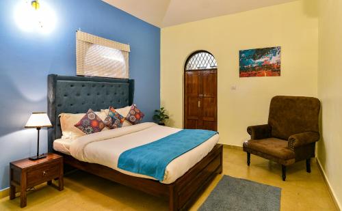1 dormitorio con 1 cama y 1 silla en GR STAYs Private Pool Villa in Calangute 5 mins to Baga, en Arpora