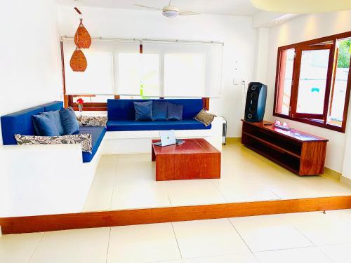 un soggiorno con un divano blu e un tavolo di VILLA TROPICAL LUX a Pipa