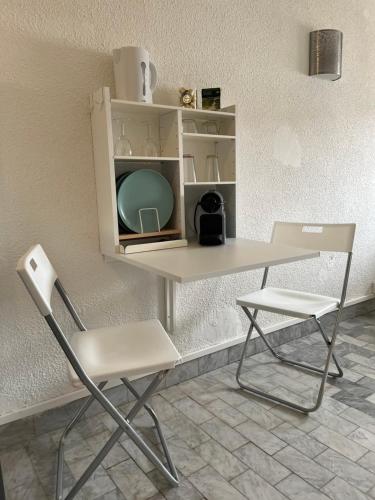 Elle comprend un bureau avec une chaise et une table avec une télévision. dans l'établissement Hendaye plage, à Hendaye