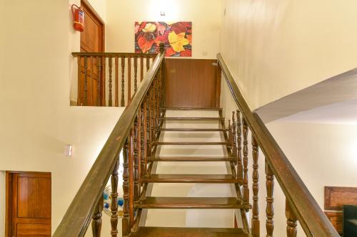 a staircase in a house with white walls and wooden railings at GR STAYs Private Pool Villa in Calangute 5 mins to Baga in Arpora