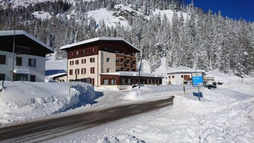 a building covered in snow in front of a mountain at Hotel Sorapiss in Misurina