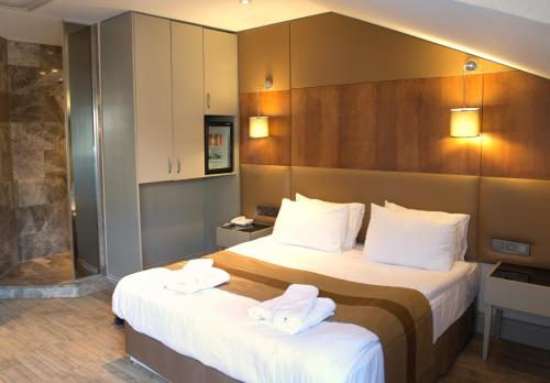 a hotel room with a bed and a desk at GK Regency Suites Hotel in Istanbul