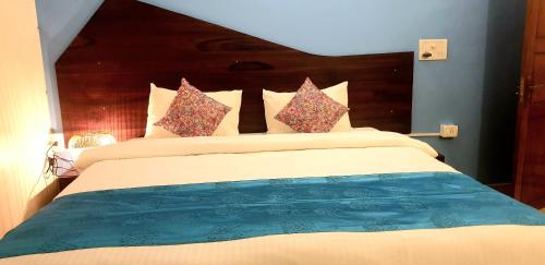 a bedroom with a large bed with a wooden headboard at GR STAYs Private Pool Villa in Calangute 5 mins to Baga in Arpora