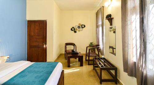 a bedroom with a bed and two chairs in it at GR STAYs Private Pool Villa in Calangute 5 mins to Baga in Arpora