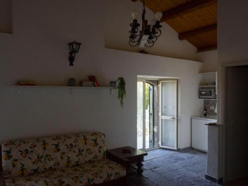 ein Wohnzimmer mit einem Sofa und einer offenen Tür in der Unterkunft Il palmento di Beppe in Santa Tecla