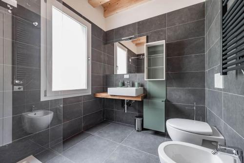 een badkamer met een toilet, een wastafel en een spiegel bij Palazzo '900 Design Flats - Il Gran Salone in Padua