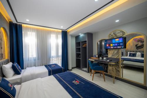 イスタンブールにあるホテル カリフォルニアのベッド2台、デスク、テレビが備わるホテルルームです。