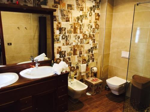 een badkamer met een wastafel, een toilet en een spiegel bij Il Sogno di Gio della Laguna in La Laguna